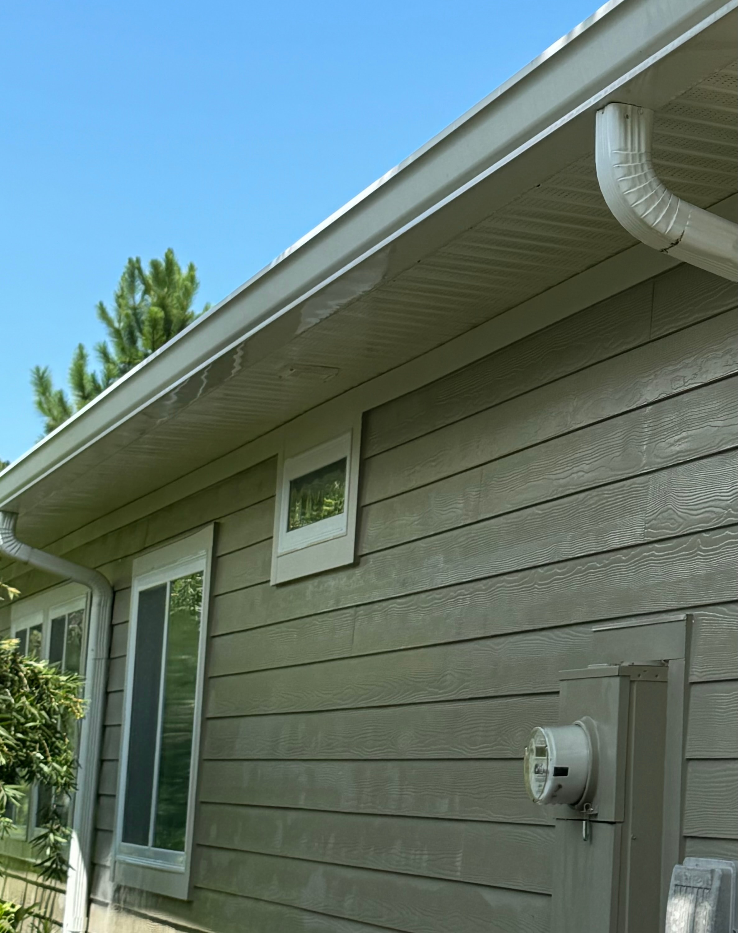 Residential house siding after soft wash cleaning — bright white clean soffits and gutters restored, Jacksonville, FL