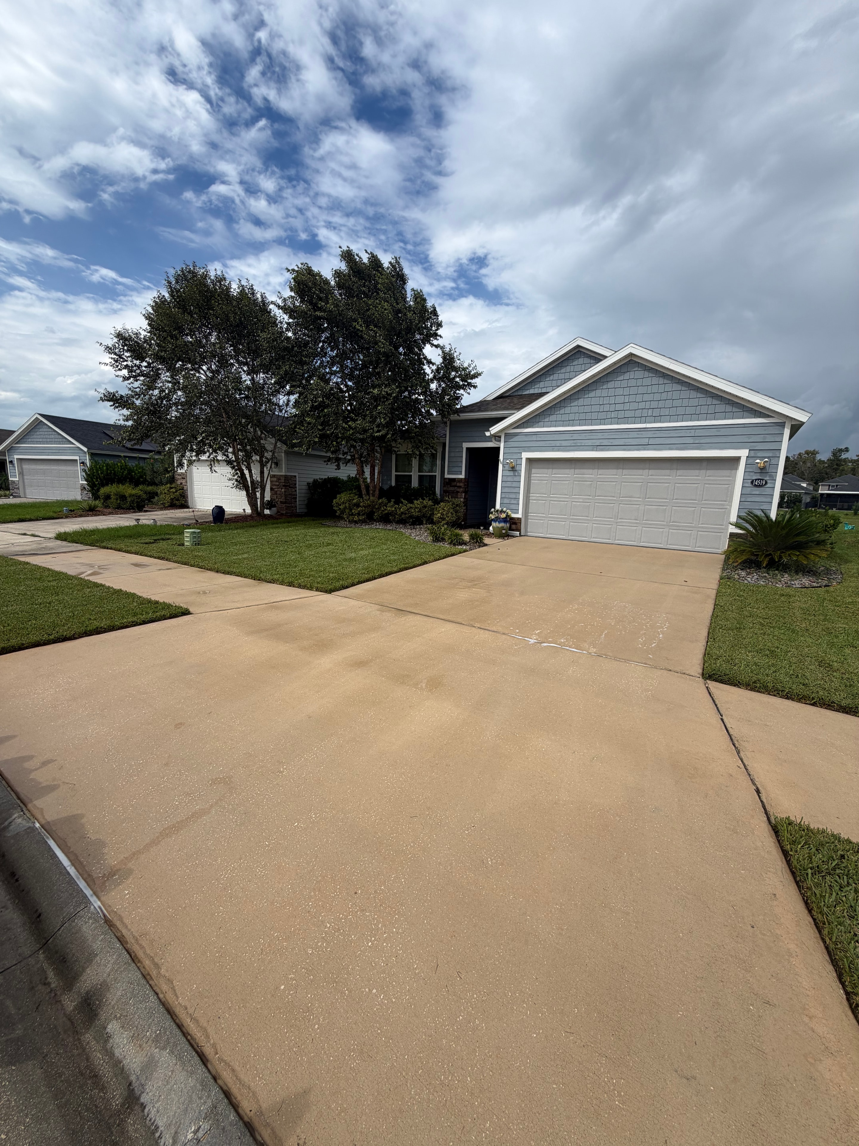 Residential driveway after pressure washing — bright clean restored concrete, Jacksonville, FL